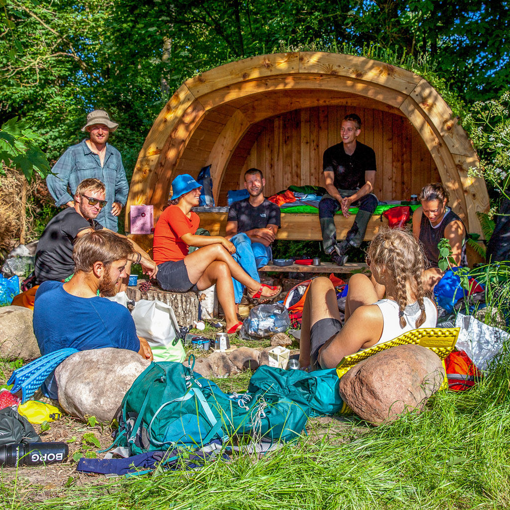 * Glade unge gæster slapper af i en luksus-glamping-schutzhütte hos Gæsteriet i Sandvig – det perfekte stop for cykelturister på ruterne Berlin-København og Munkevejen.